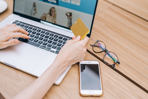 Joven comprando online con su tarjeta de crédito en mano
